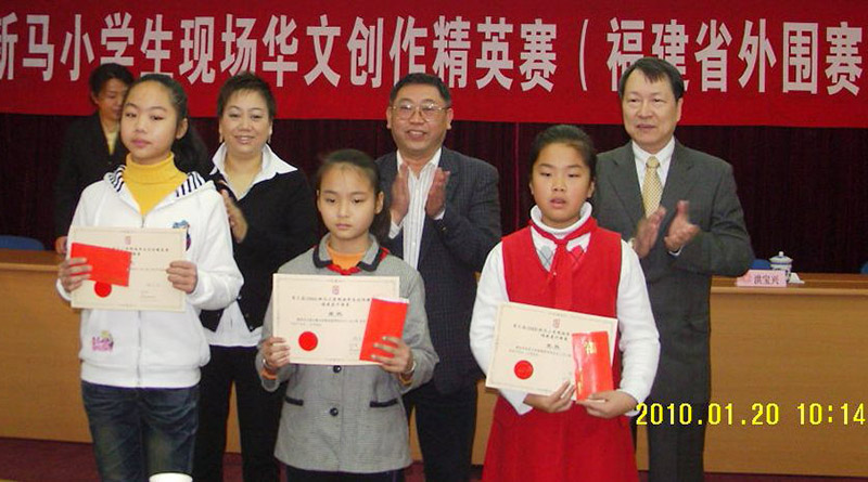 洪宝兴(后排右一)、王品桦(后排左一)与福建省侨联副主席杨峥嵘(后排中)为各组冠军获得者颁奖 (前排左起分别是甲组冠军林雨情,乙组冠军蔡杰超,丙组冠军杜容熙)